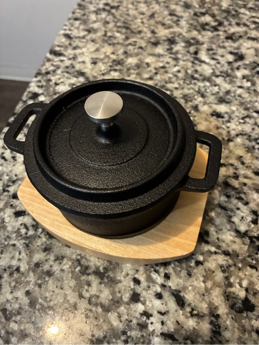Black Cast Iron Mini Dutch Oven with Lid and wood trivet